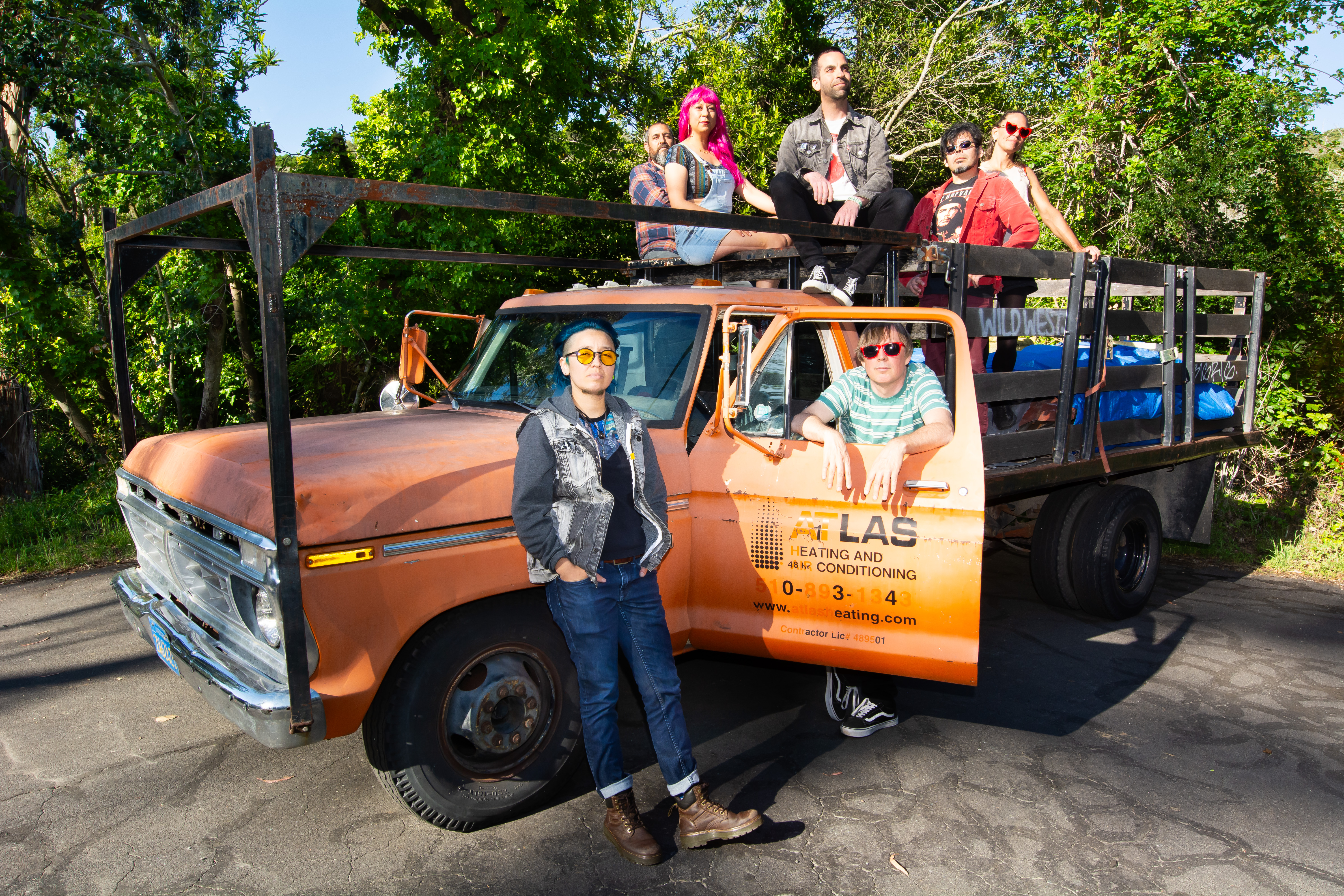 members of Ritmos Tropicosmos posing around an old orange truck 